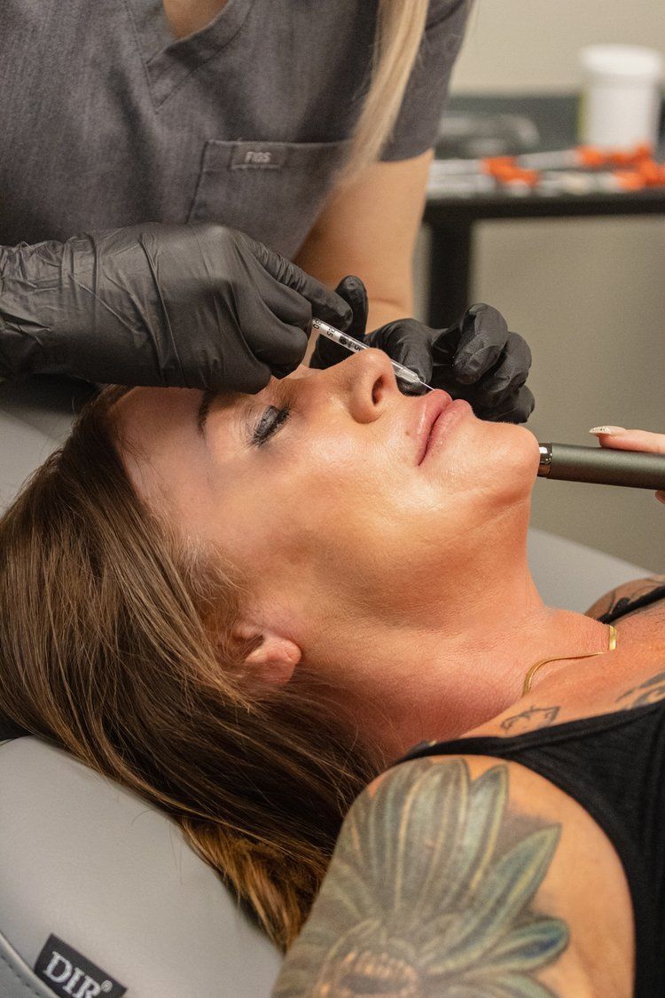 A woman is getting a botox injection in her face.