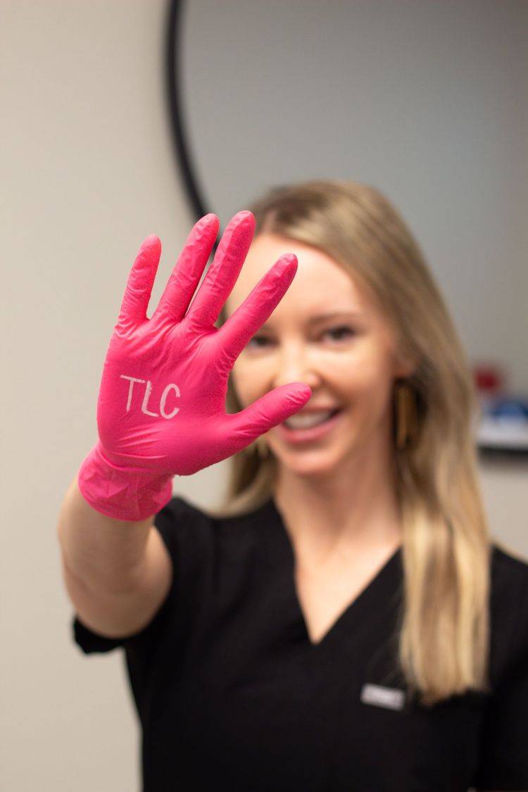 A group of women in black scrubs are posing for a picture.