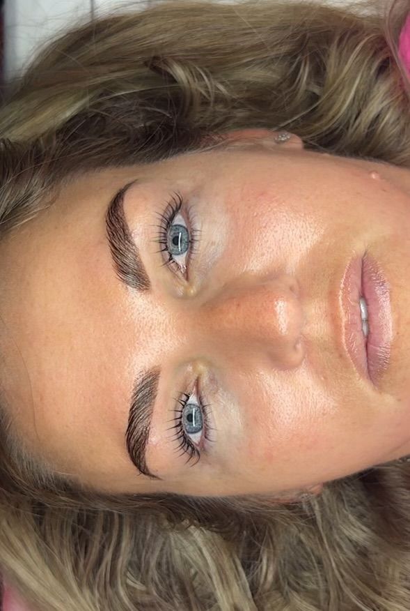 A woman is getting her eyelashes done at a beauty salon.