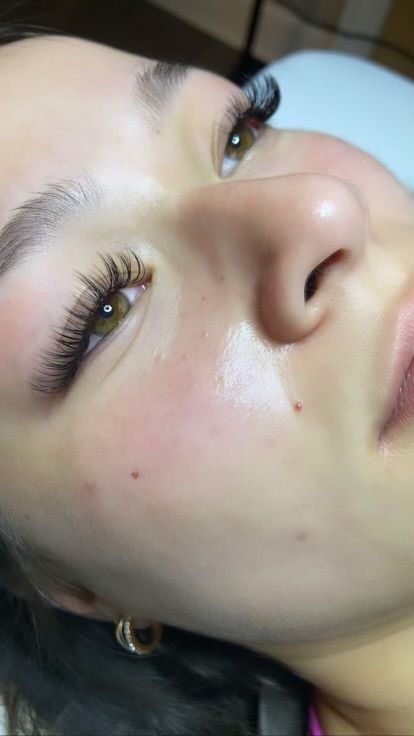 A close up of a woman 's face with long eyelashes.