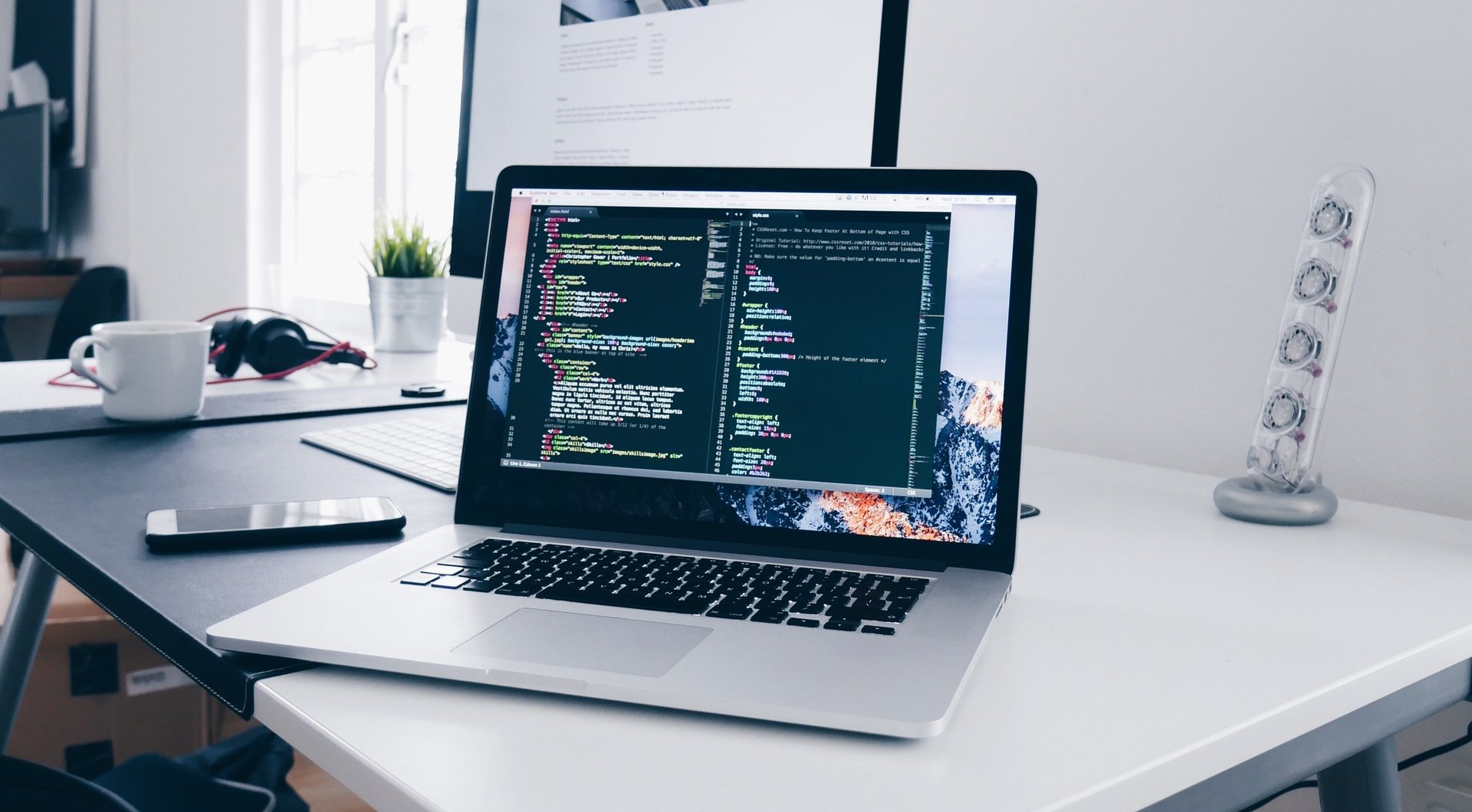 A laptop computer is sitting on top of a white desk.