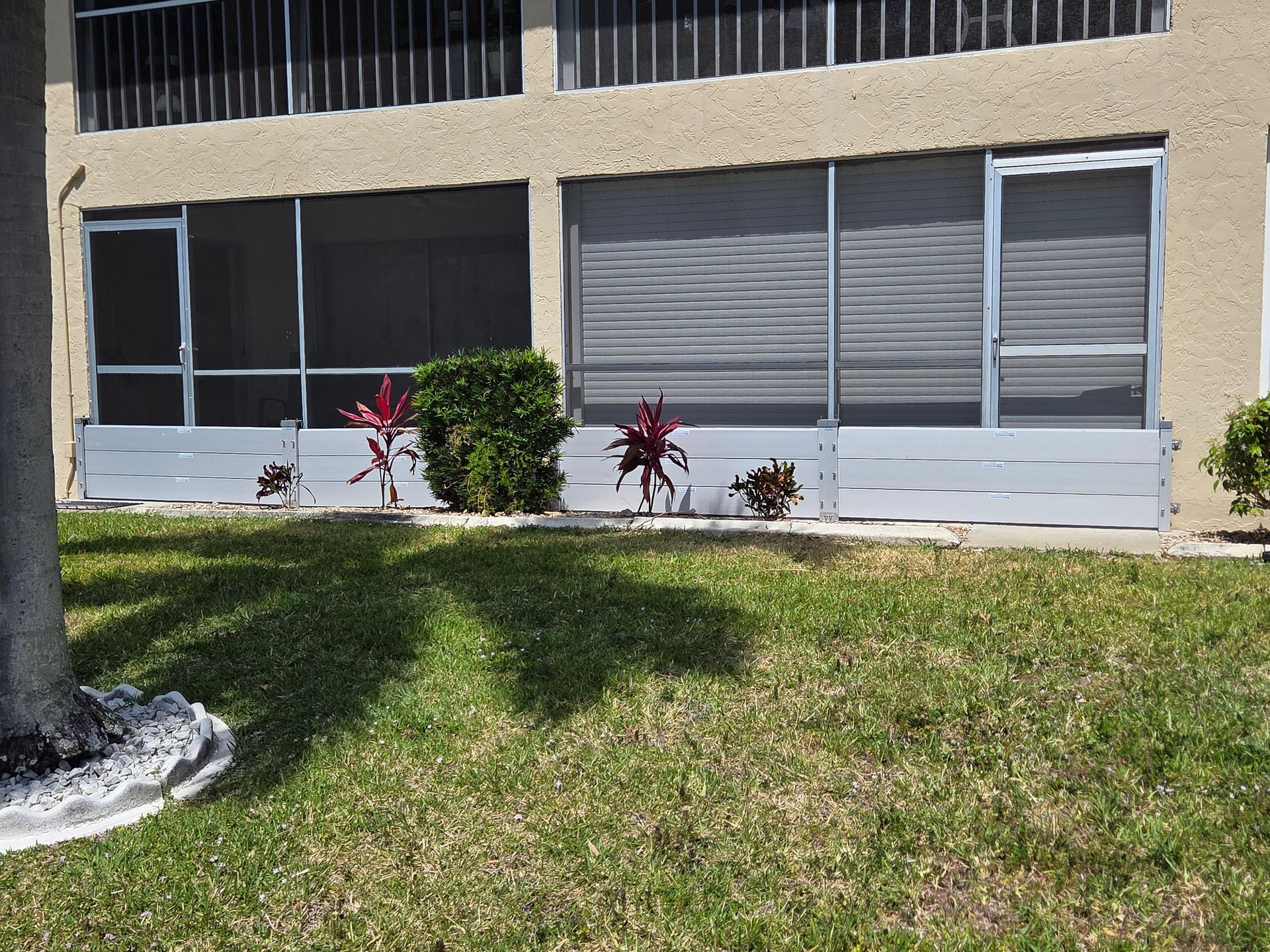 A screened in porch with a tree in front of it