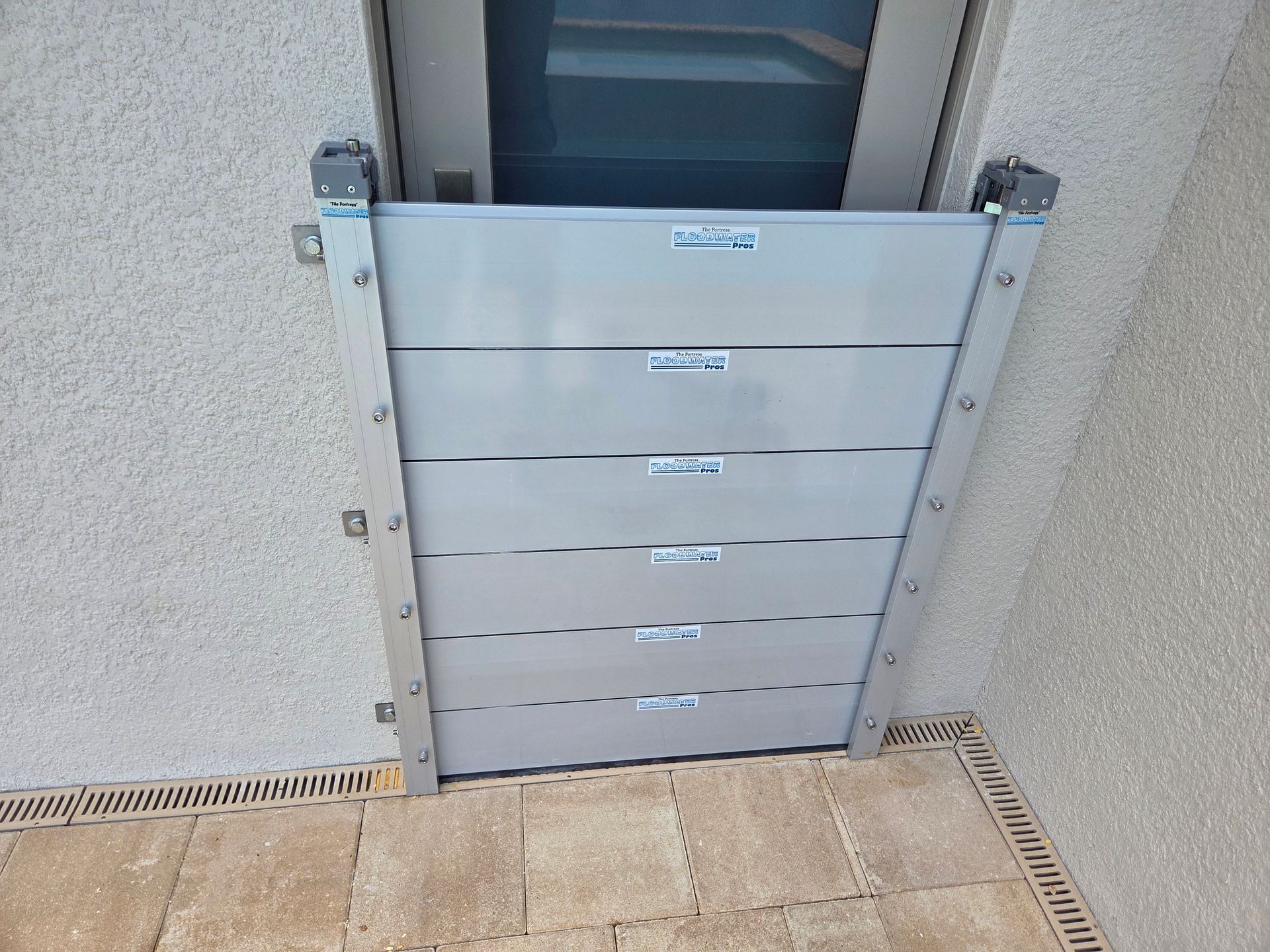 A flood barrier is sitting on the side of a building next to a door.