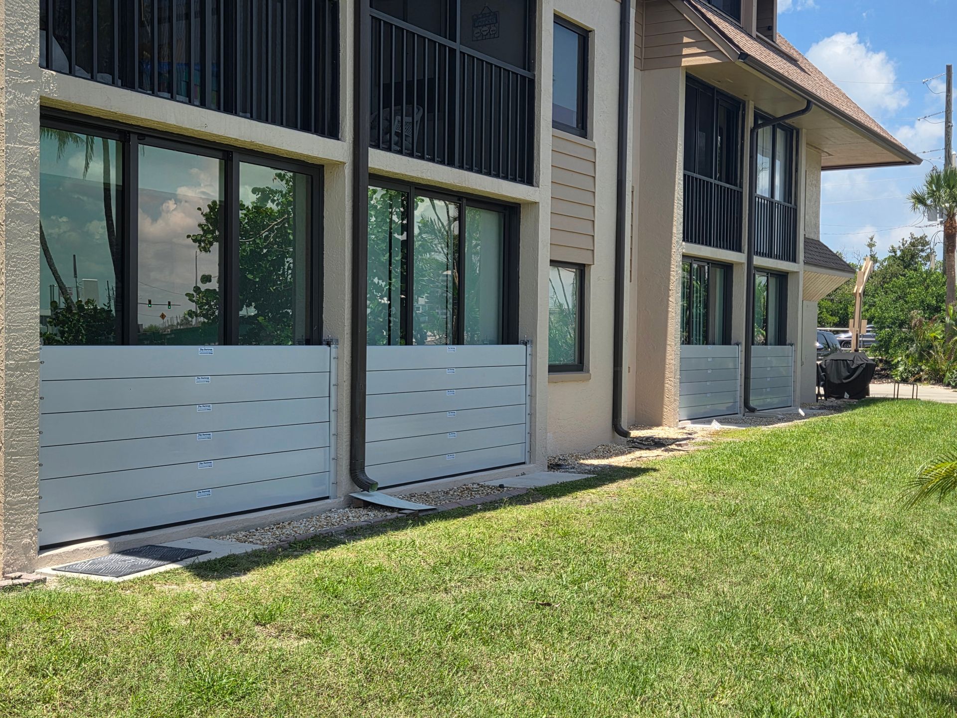 A building with a lot of windows and a lawn in front of it.