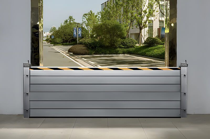 A flood barrier is sitting on the sidewalk in front of a building.