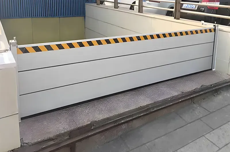A flood barrier is sitting on the sidewalk next to a building.