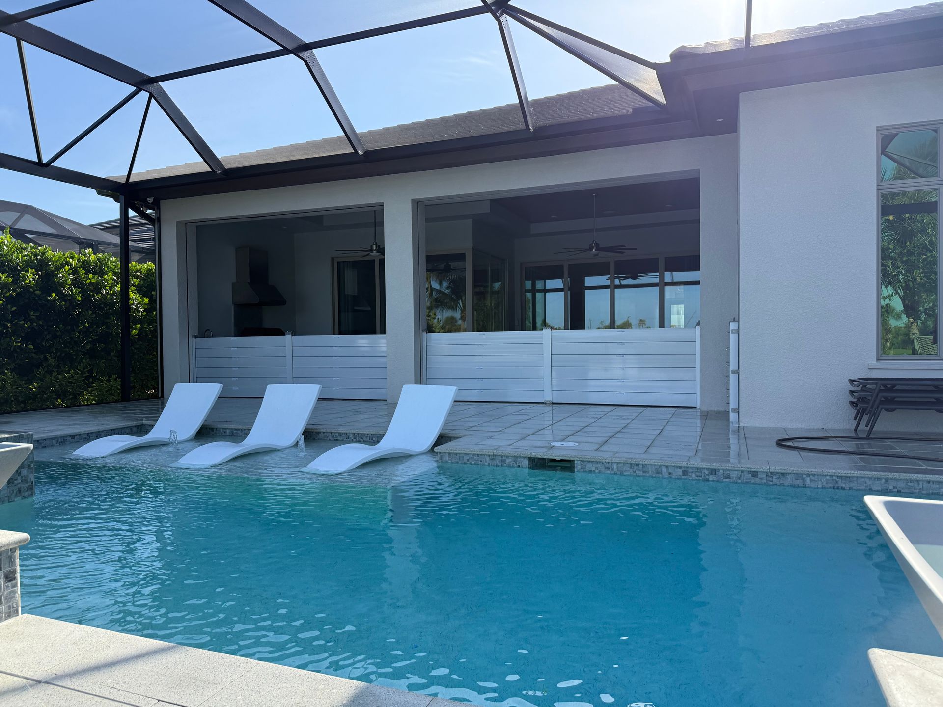 There is a large swimming pool in the backyard of a house.