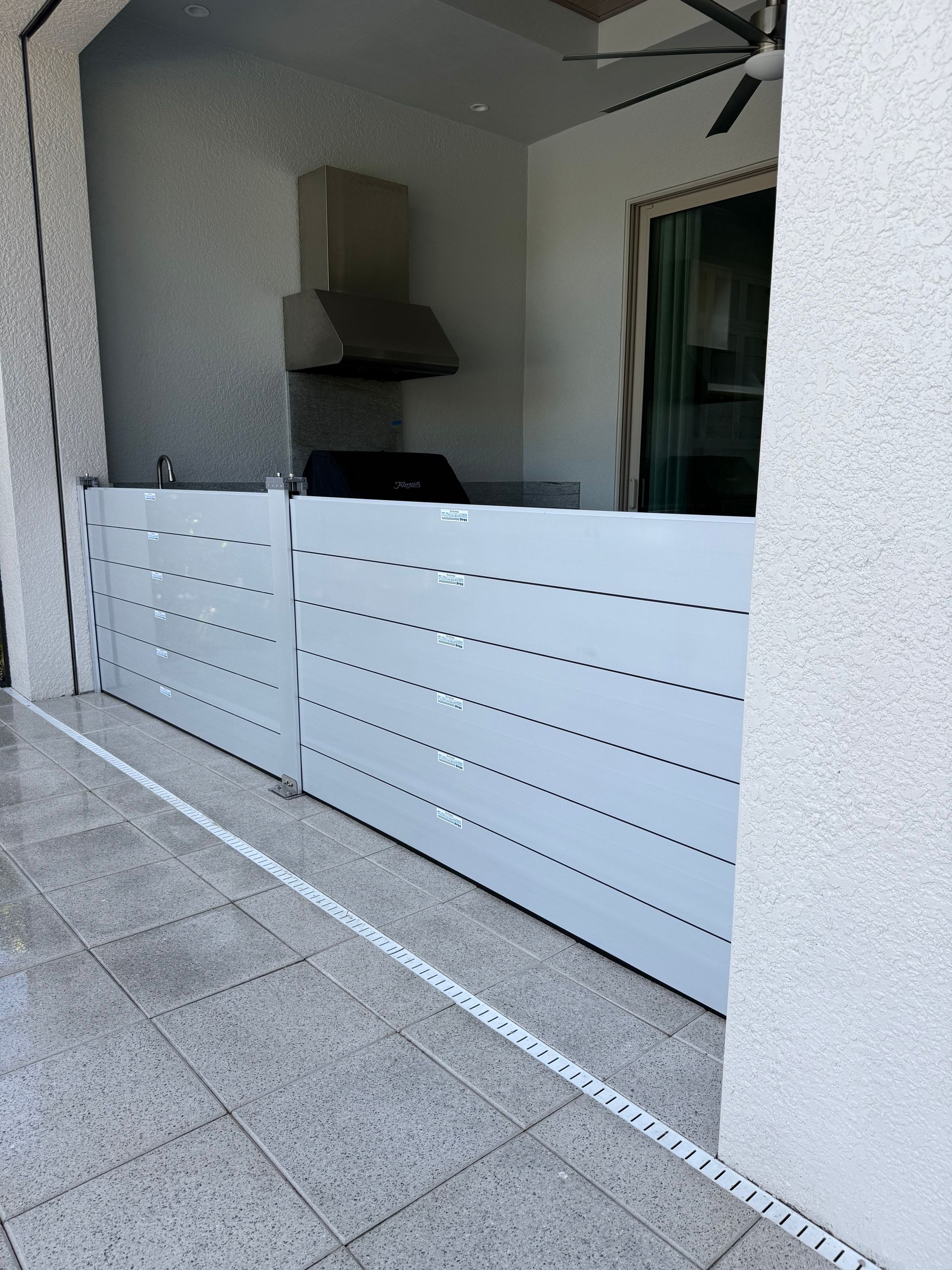 A white fence is sitting on a tiled floor next to a window.