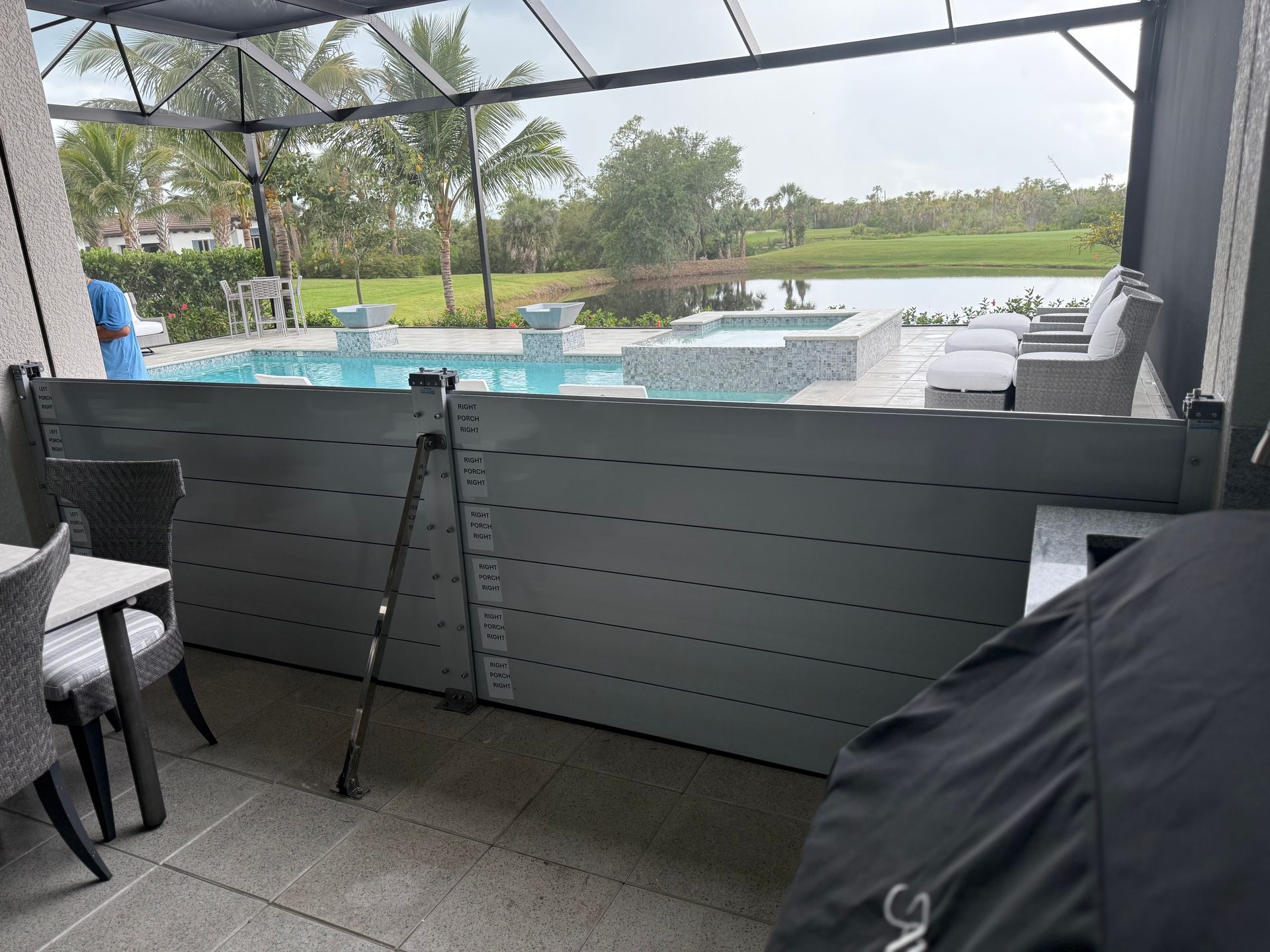 A patio with a table and chairs and a pool in the background.