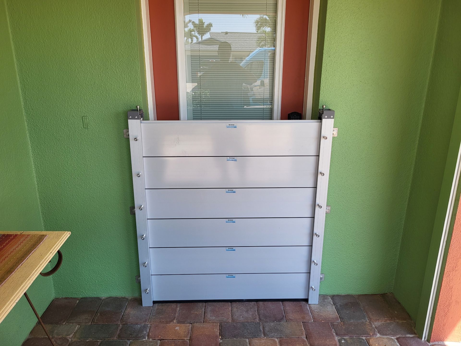 A green wall with a white barrier in front of a door