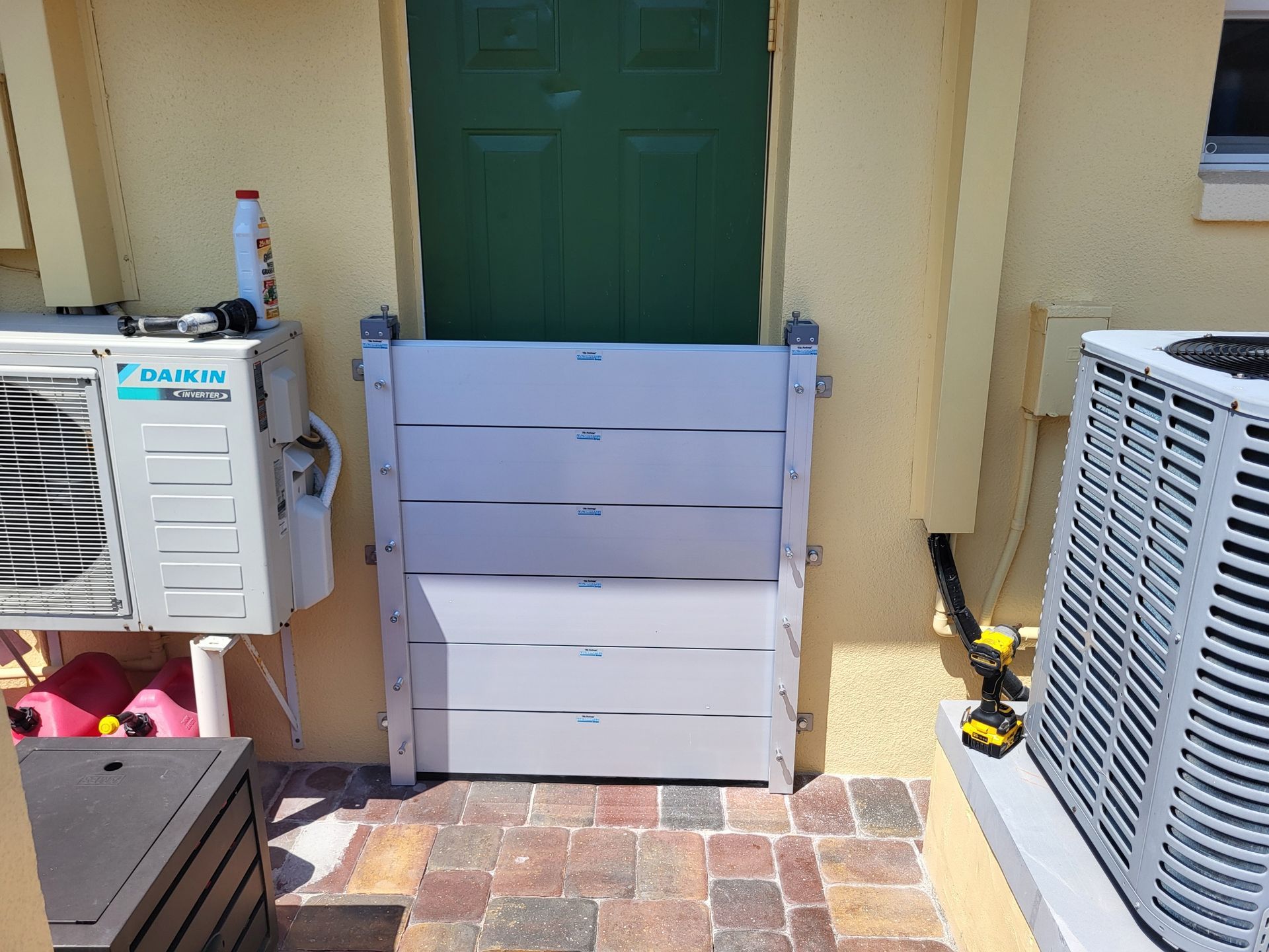 A white flood barrier is sitting in front of a green door.