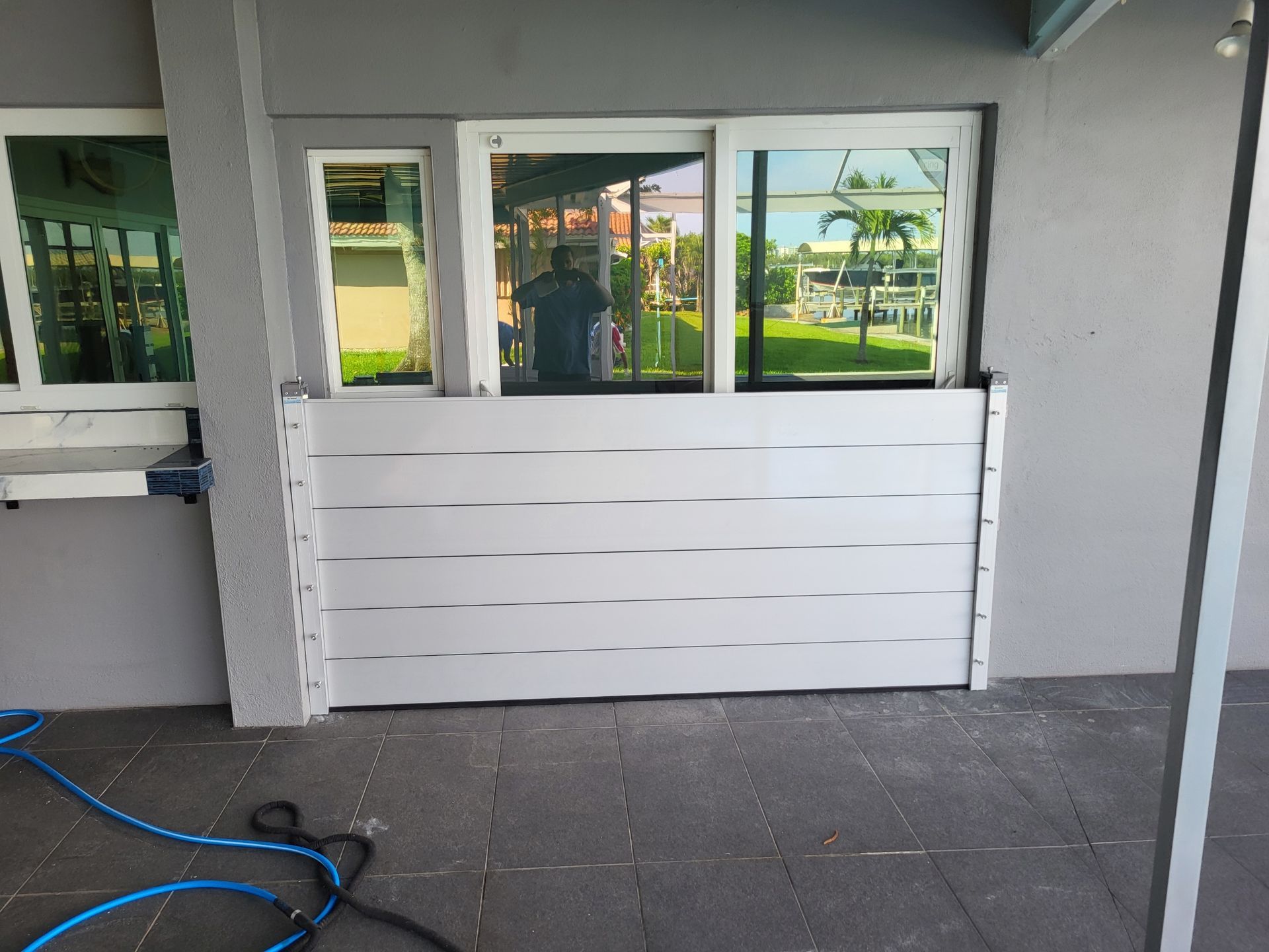 A white door with a hose in front of it