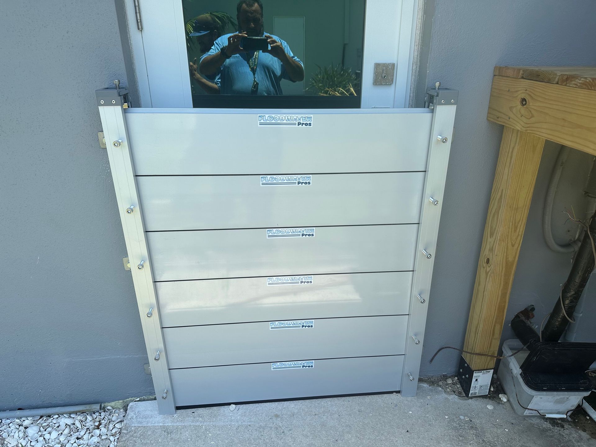 A man is taking a picture of himself in the mirror of a door.