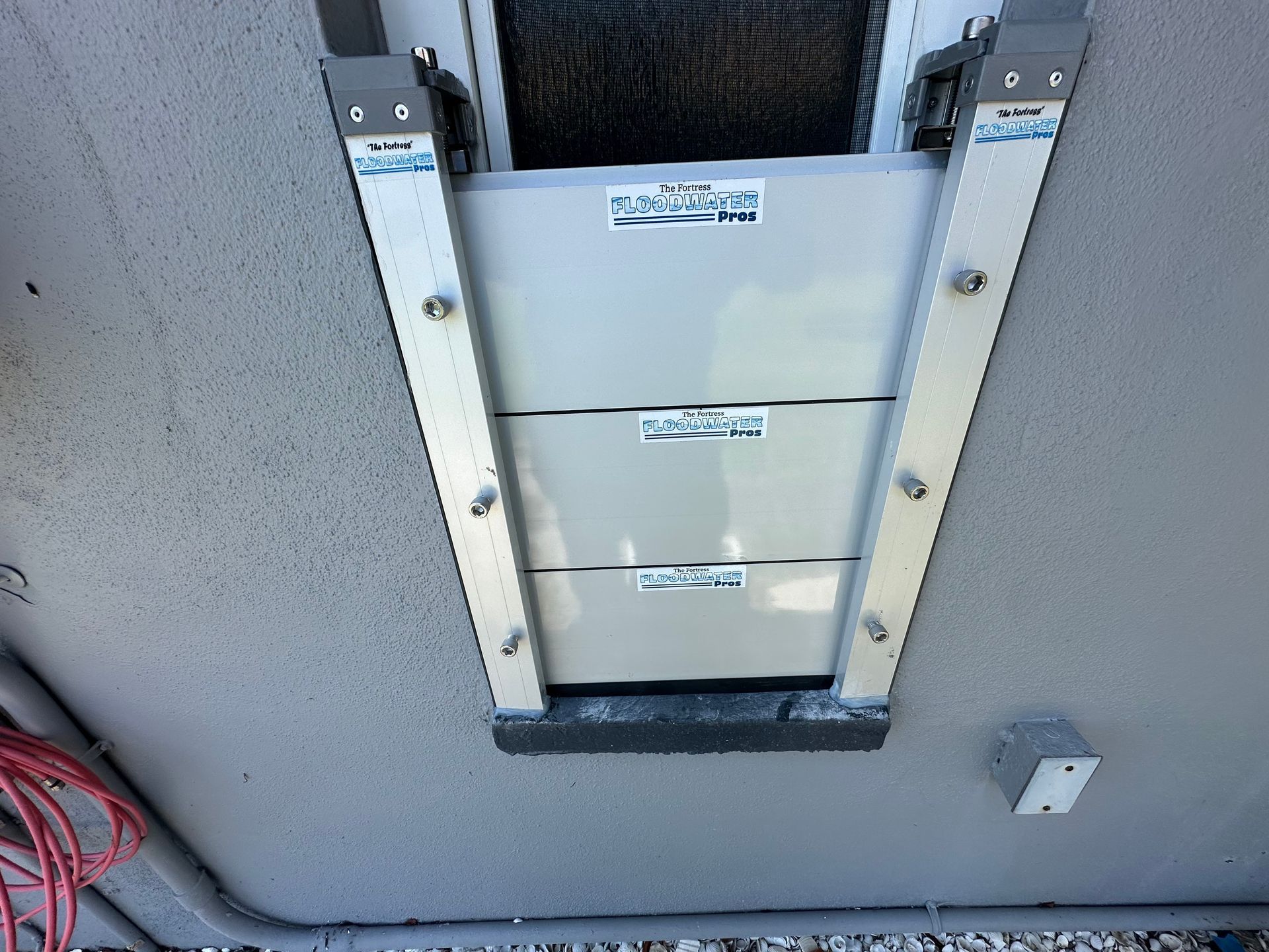 A white box with a sticker on it is hanging from the ceiling of a building.