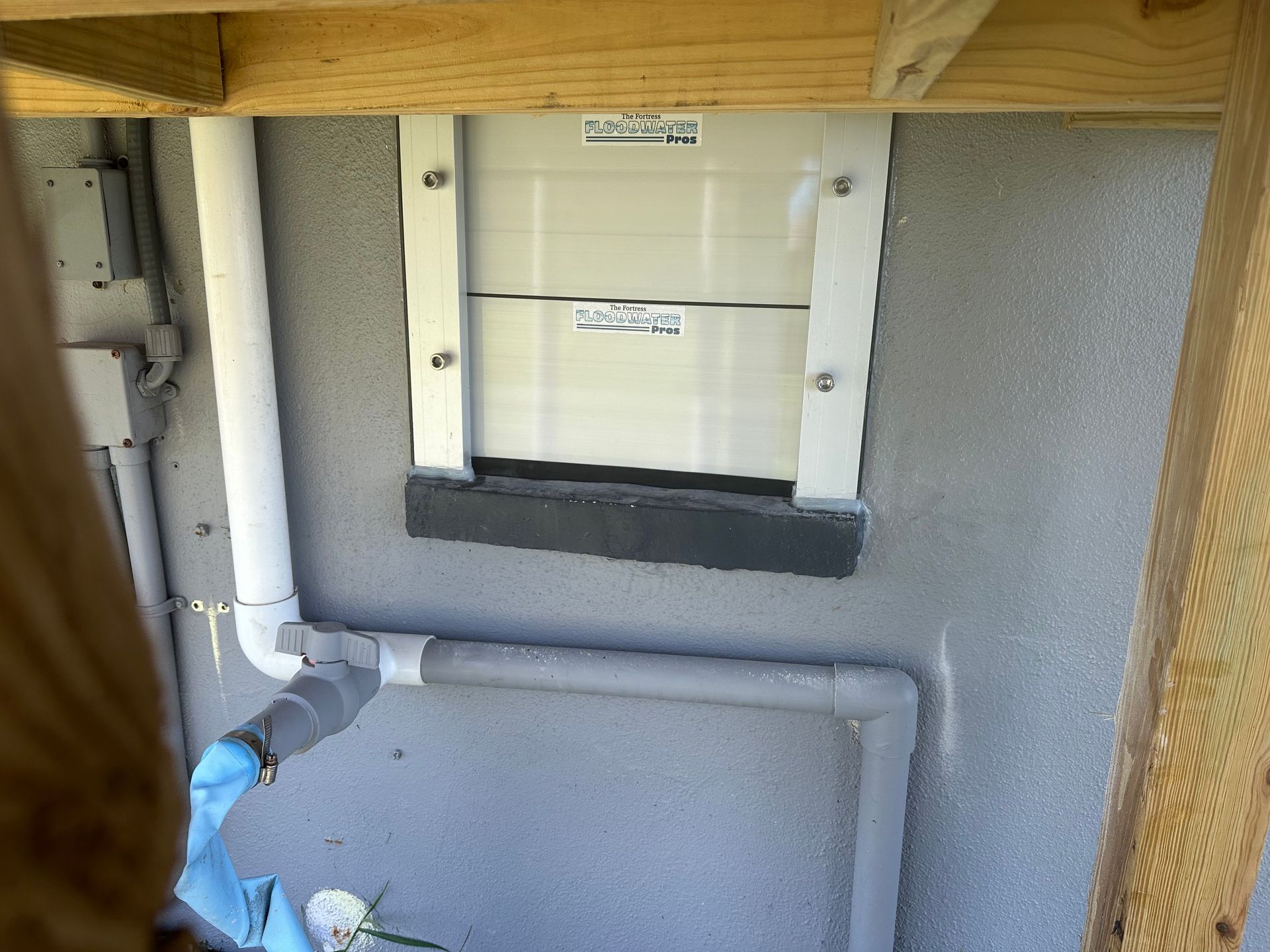 A wall with a window and pipes on it.