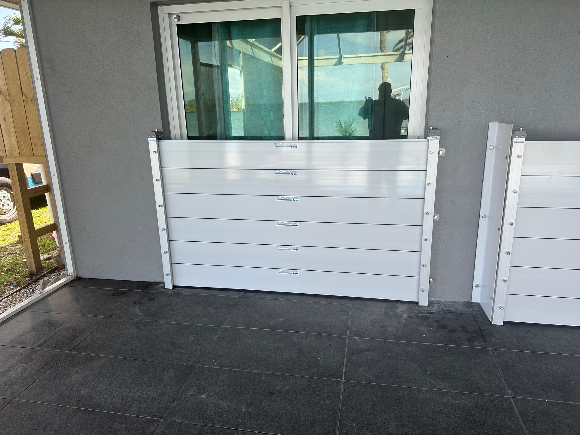 White flood barrier installed against a window, protecting a building from potential water damage.