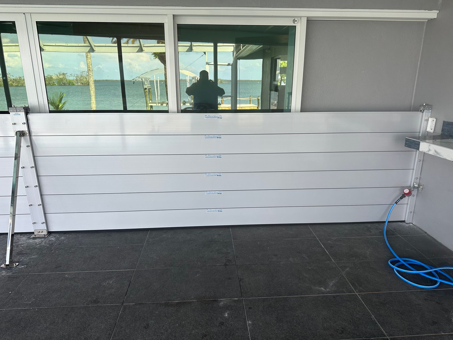 A white wall with a blue hose attached to it