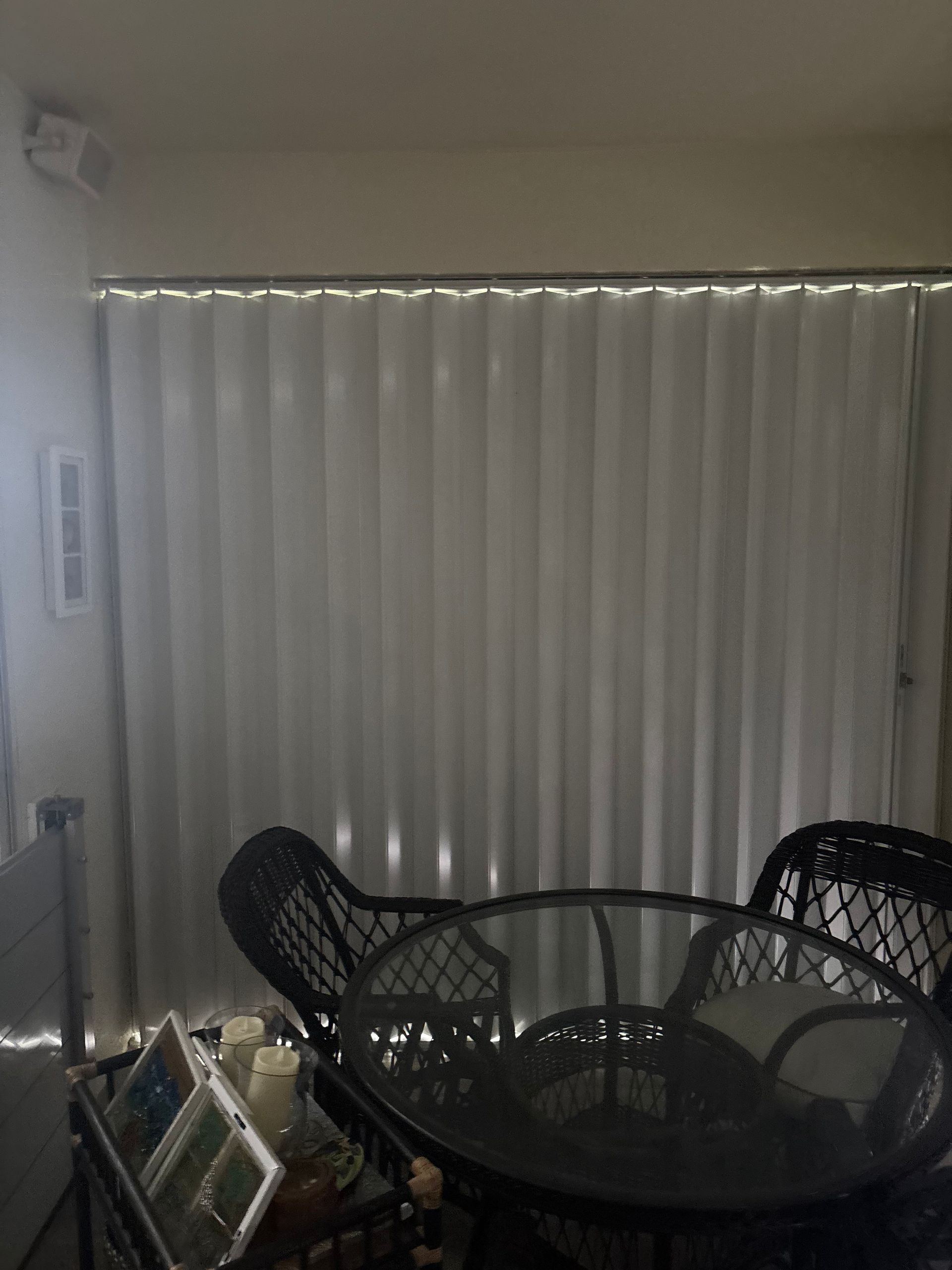 A living room with a table and chairs in front of a window.