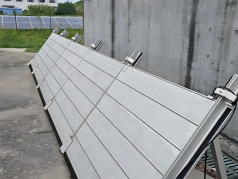 A concrete wall with a row of solar panels in the background