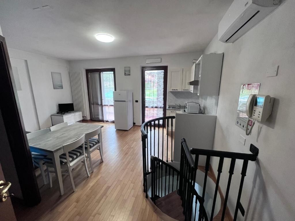 Interno di un appartamento con cucina, zona pranzo e scala a chiocciola.