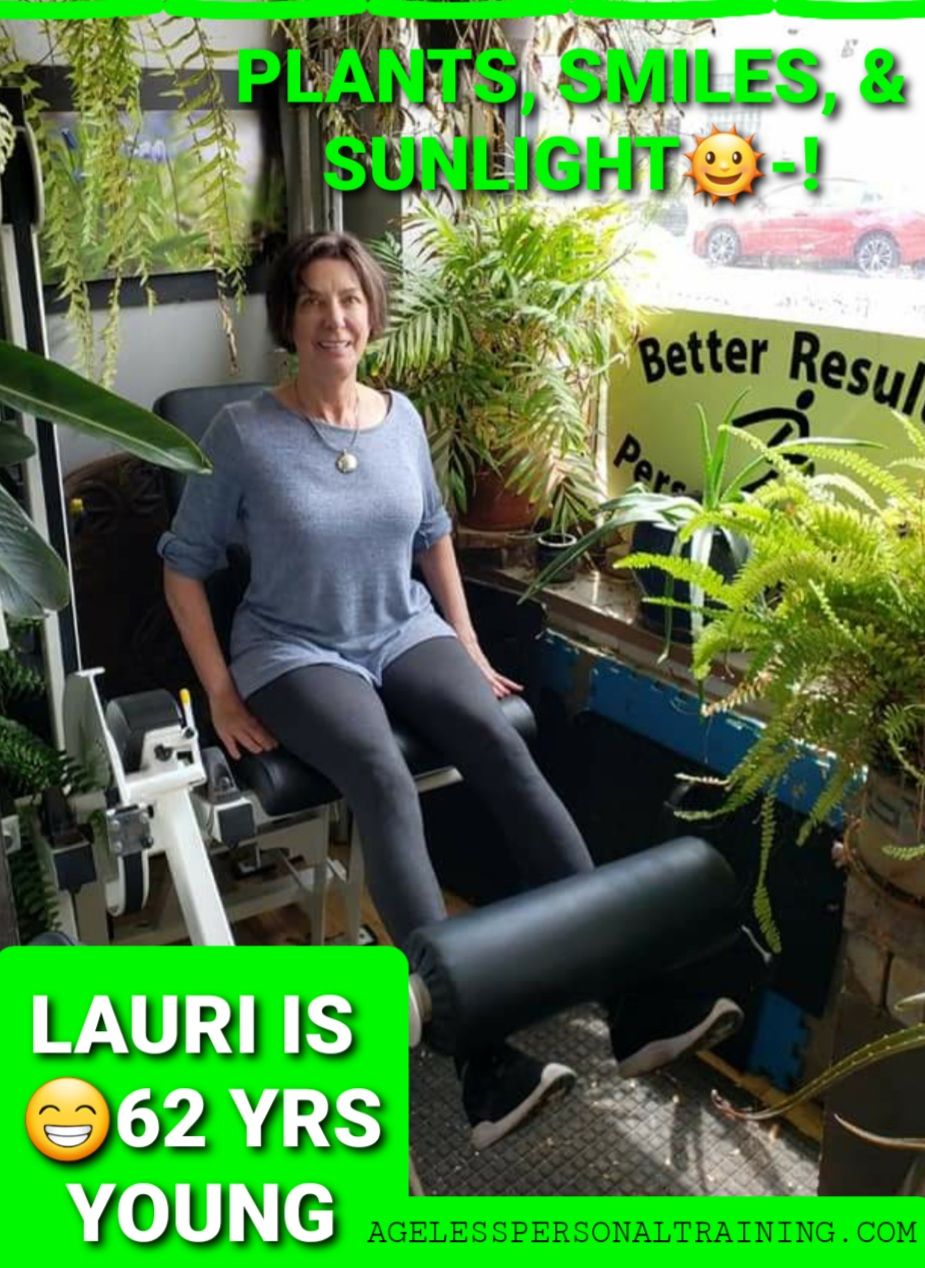 A woman is sitting on a machine in a gym surrounded by plants.