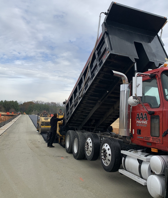 Tracked paver laying fresh asphalt pavement in NC