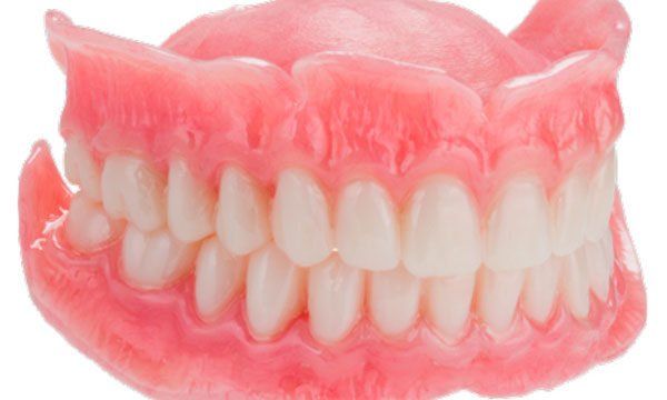A close up of a denture with white teeth on a white background.