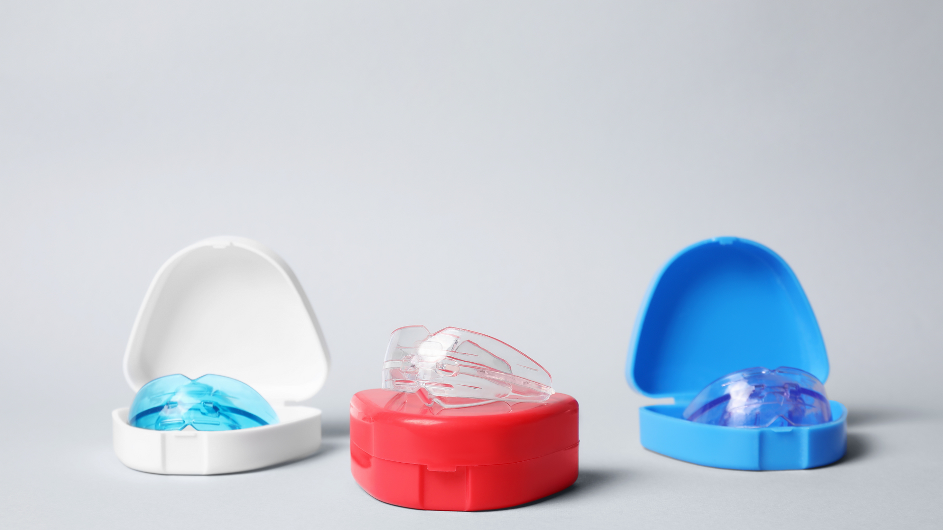 A red , white , and blue container filled with dental appliances.