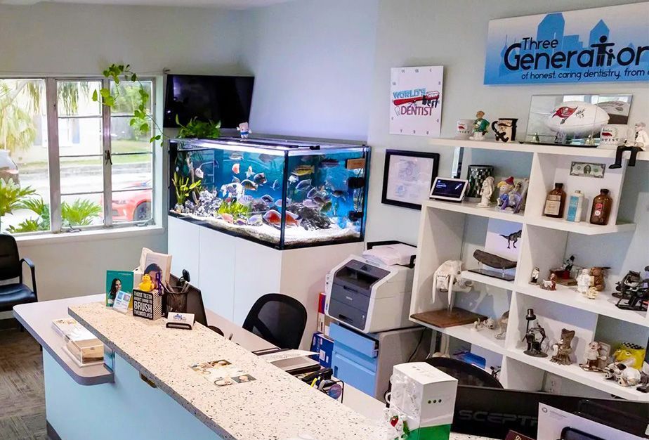 A reception area with a fish tank and a sign that says third generation