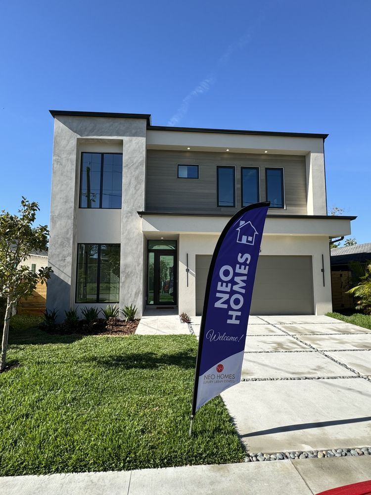 Modern two-story suburban home with a flat roof, light stucco and wood siding, and a Neo Homes promotional flag.