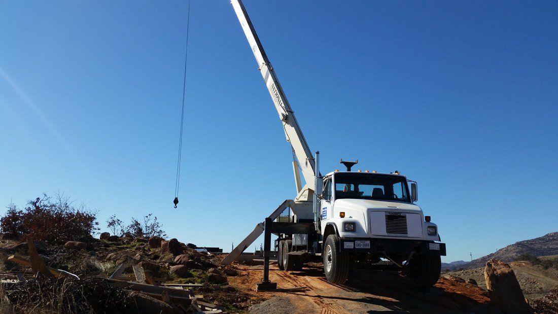 A white truck with a crane attached to it