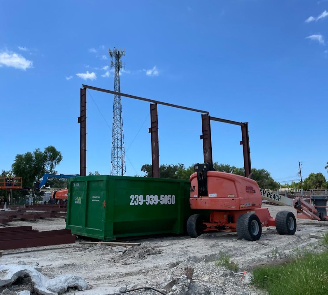A green dumpster with a phone number on it