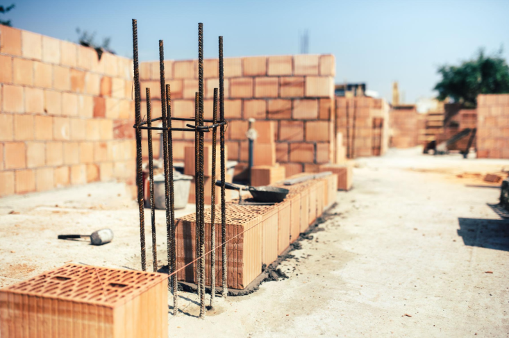 “Partially built brick wall with vertical rebar supports ready for reinforcement during a masonry service in Friendswood, TX”