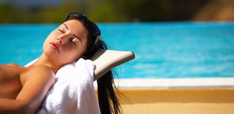 Woman sunbathing near the swimming pool