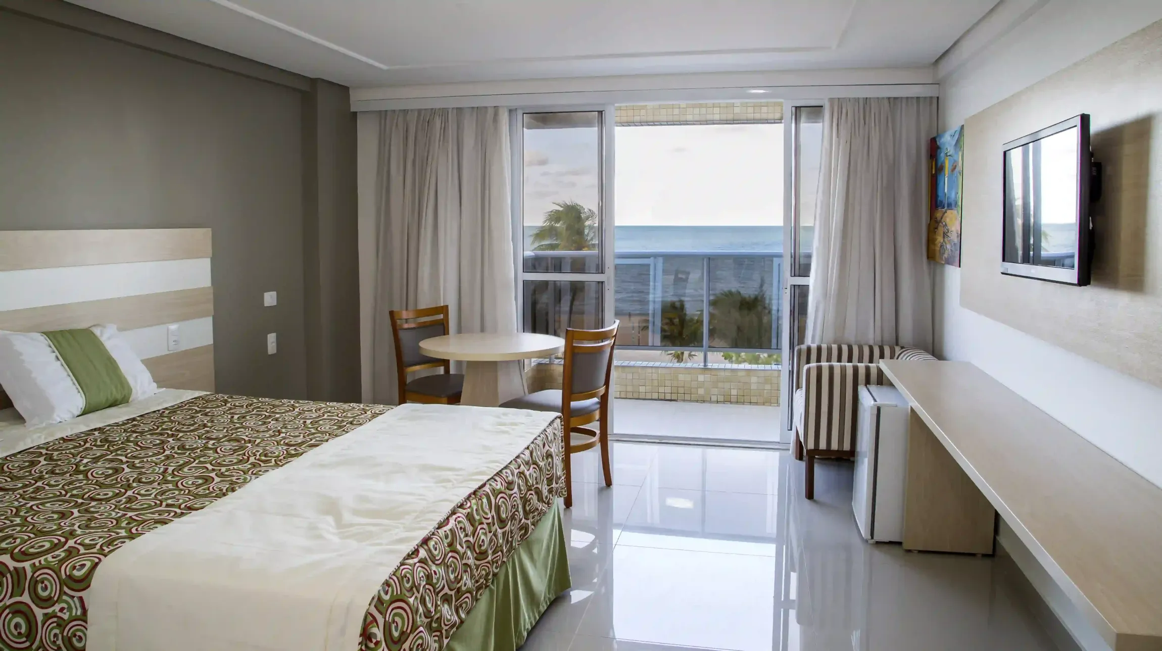 Um quarto de hotel com uma cama grande e uma mesalaguna-praia-hotel