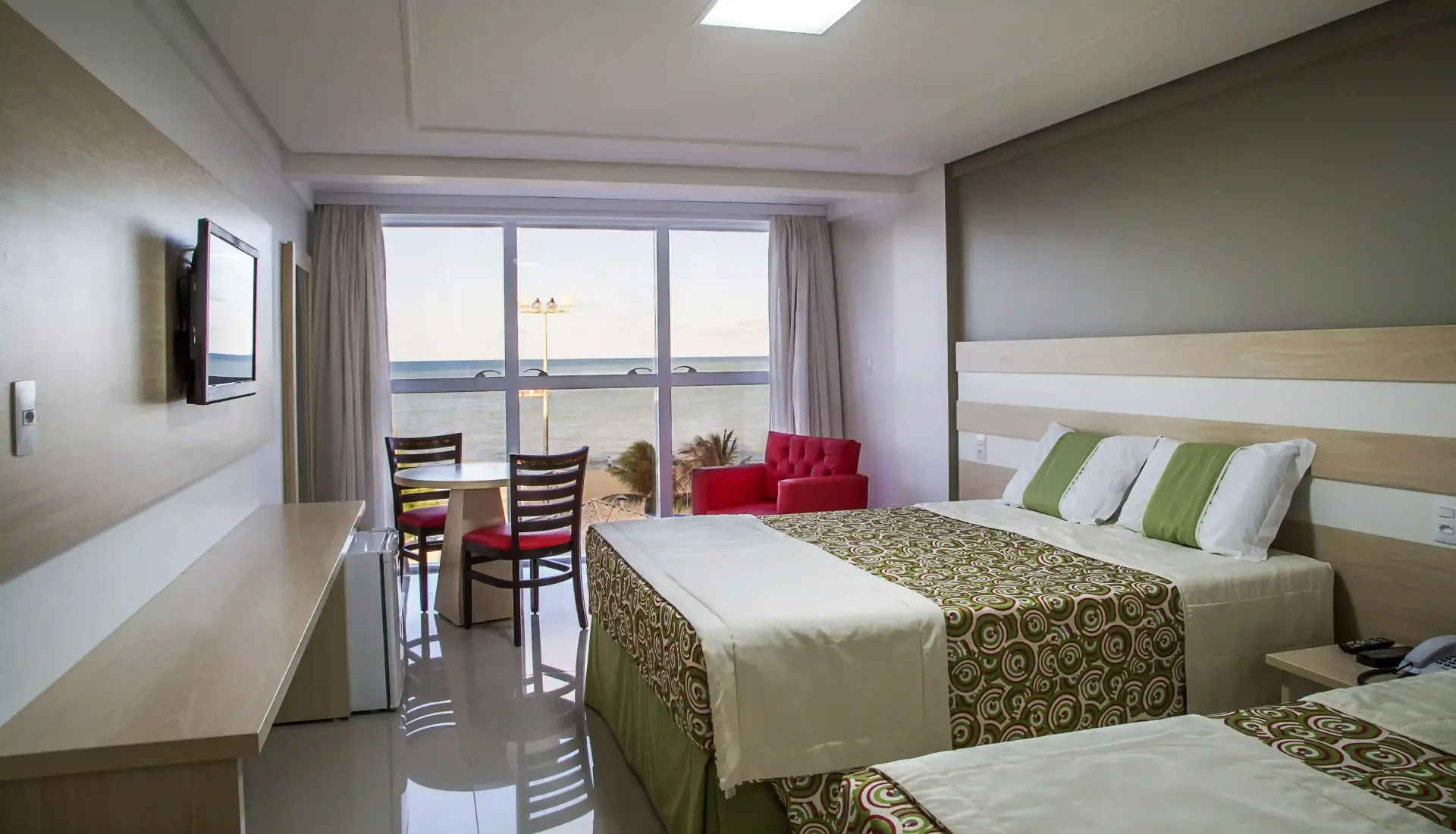 Um quarto de hotel com duas camas e uma televisãolaguna-praia-hotel