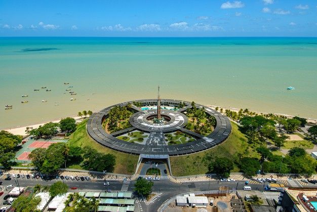 Uma vista aérea de um grande edifício no meio de um parque próximo ao oceano.laguna-praia-hotel