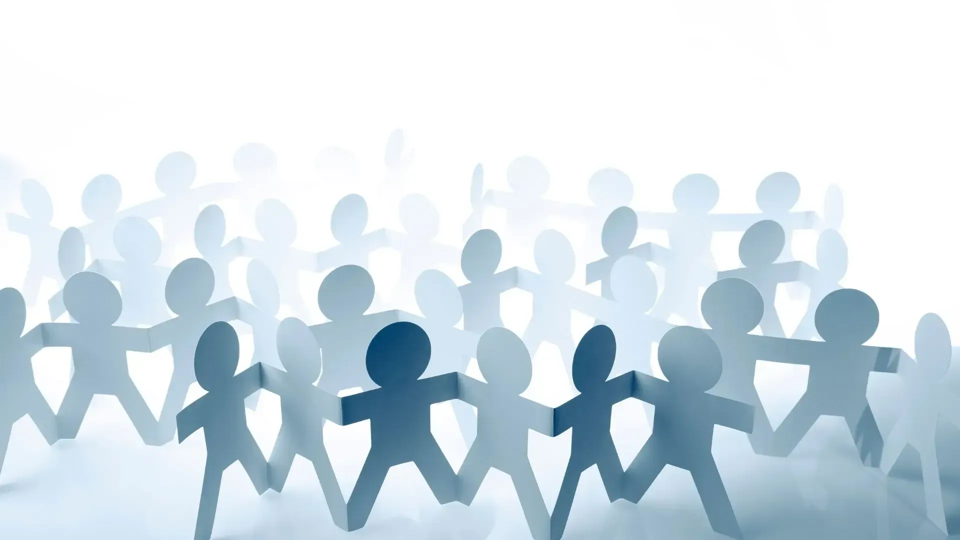 A group of paper people are holding hands in a circle.
