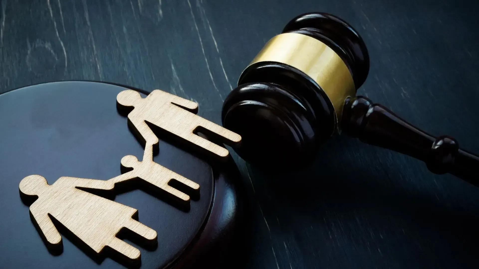 A wooden family is sitting on top of a wooden gavel.