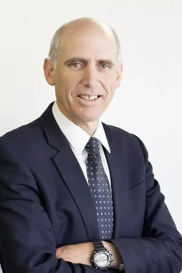 Adrian Sullivan in a suit and tie is wearing a watch that says 10:08