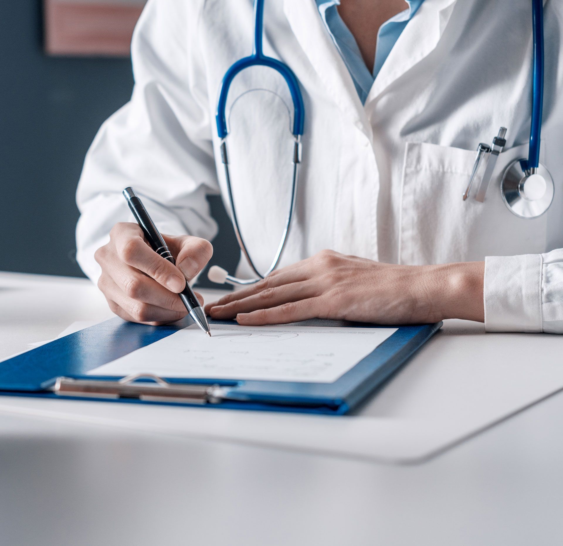 A doctor is writing on a clipboard while talking to a patient.