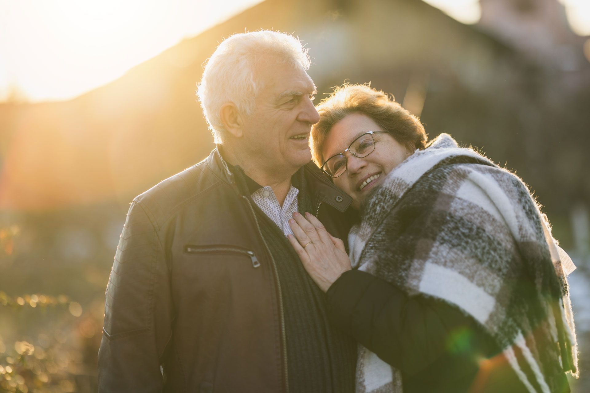 A man and a woman are standing next to each other and hugging.