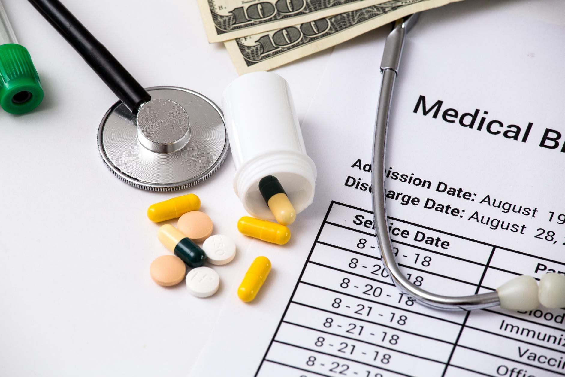 A medical bill with a stethoscope and pills on it.