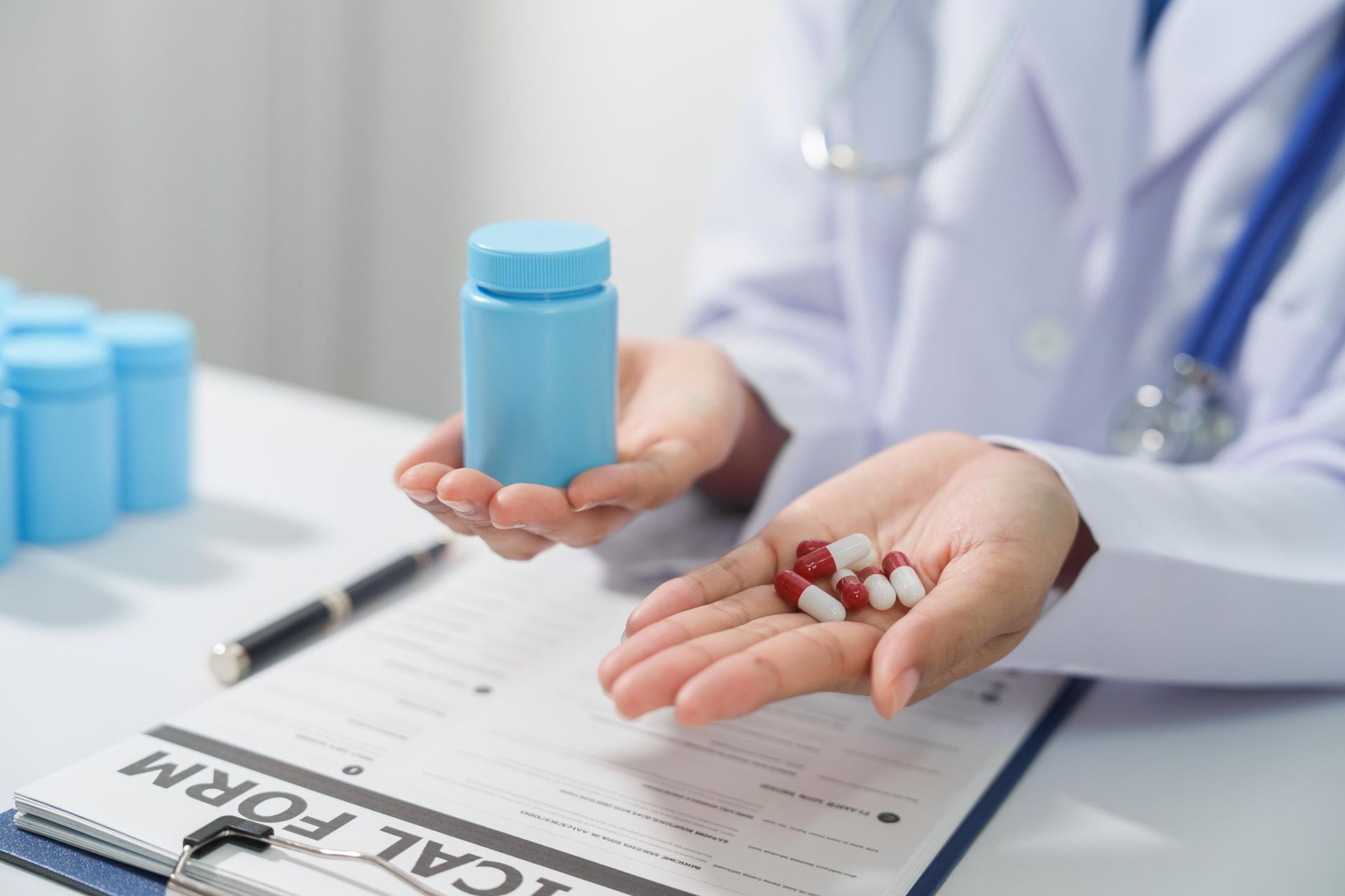 A doctor is holding a bottle of pills in her hand.