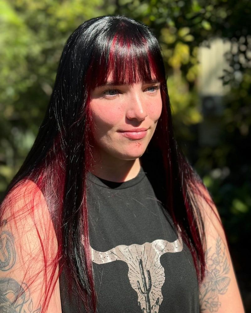 A Woman With Long Black Hair And Red Highlights Is Wearing A Black Shirt — Sarina Hair Fashions in Sarina, QLD