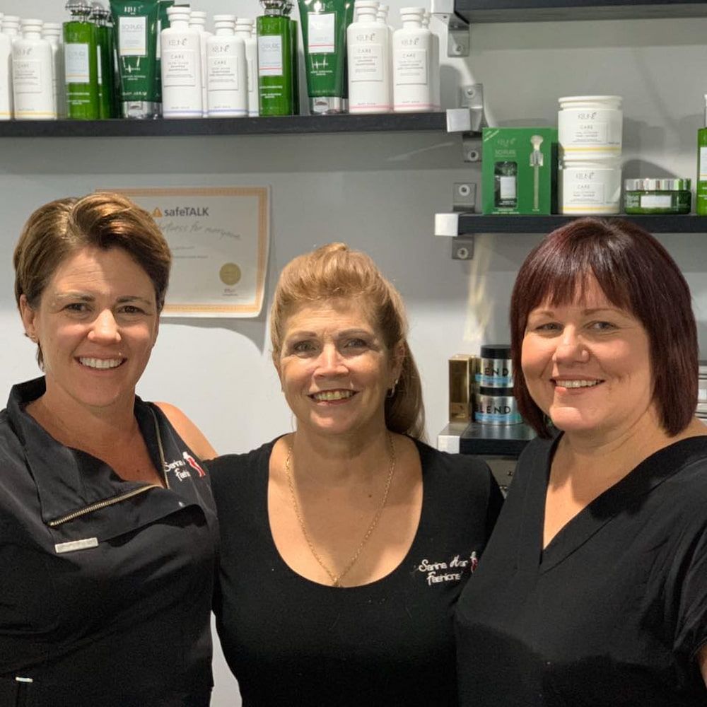 Three Women Are Posing For A Picture In Front Of A Shelf Full Of Beauty Products β Sarina Hair Fashions in Sarina, QLD