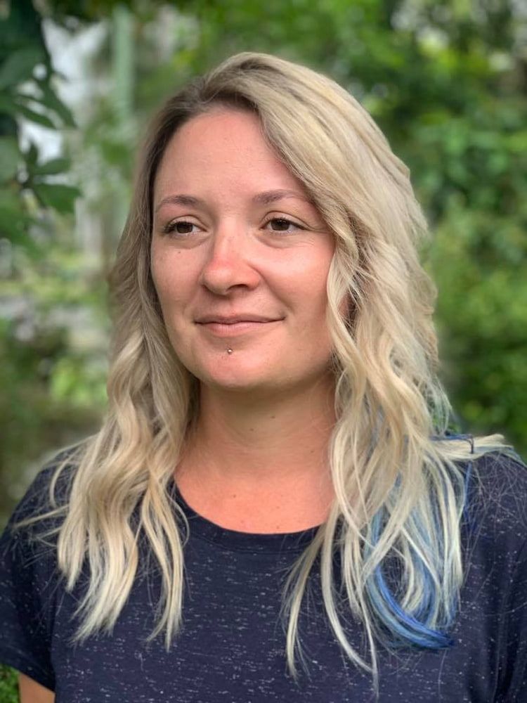 A Woman With Blonde Hair And Blue Streaks Is Wearing A Blue Shirt — Sarina Hair Fashions in Sarina, QLD