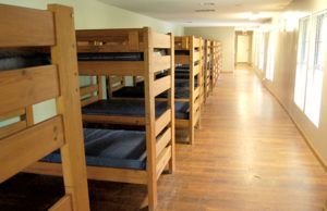 A row of bunk beds are lined up in a hallway.