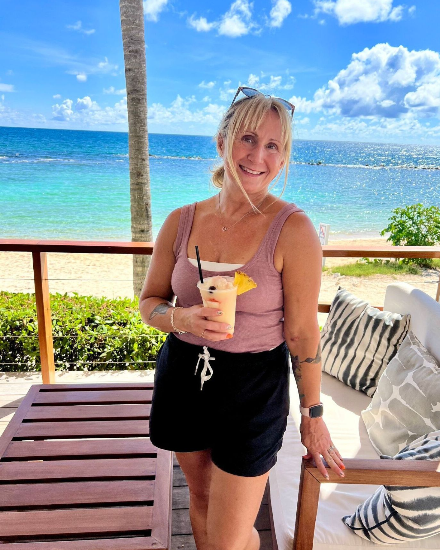 Woman with a tropical drink at a resort on a Caribbean beach