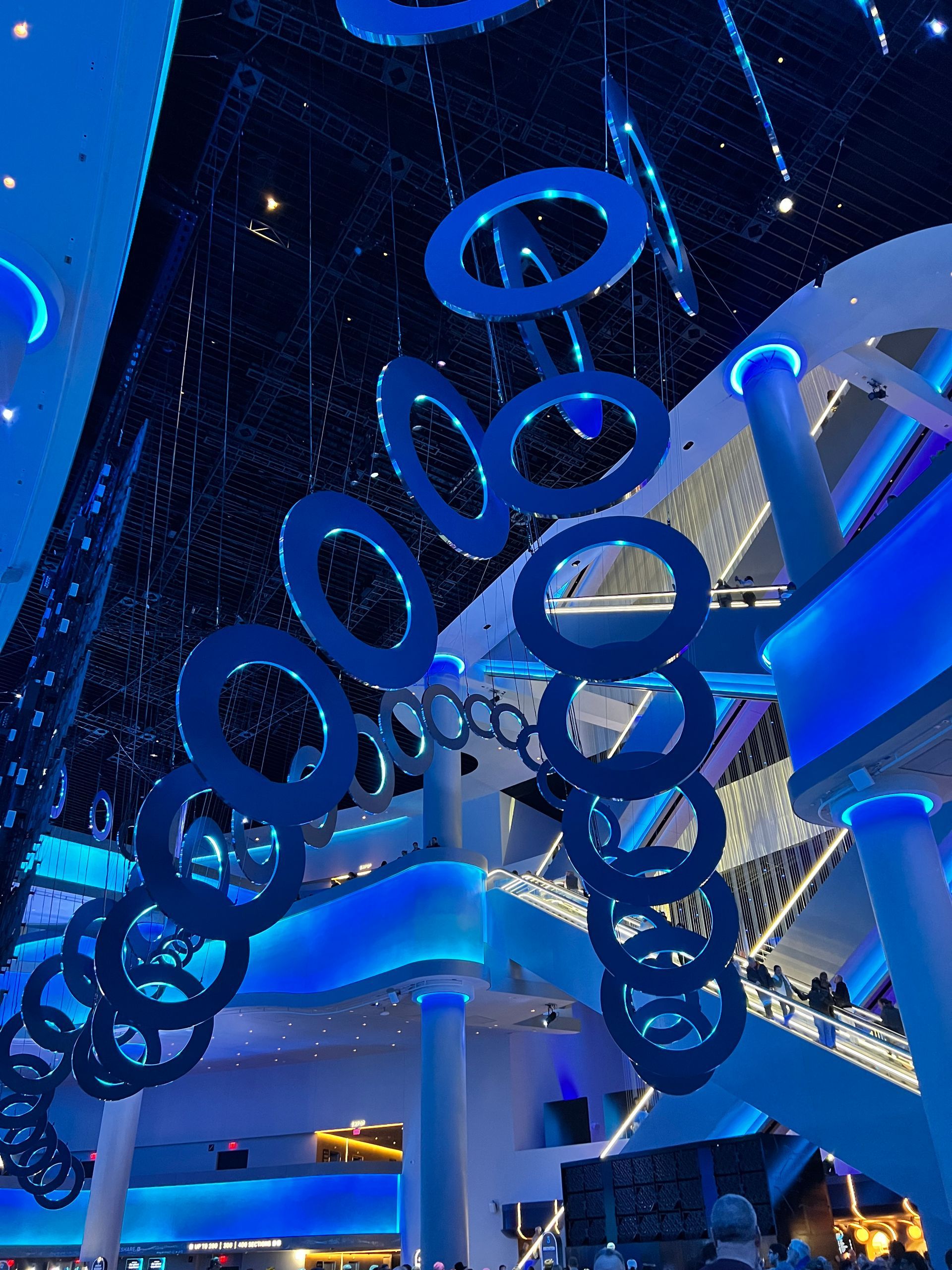 Blue-lit interior with floating blue rings, stairs, and columns in the Las Vegas Sphere.